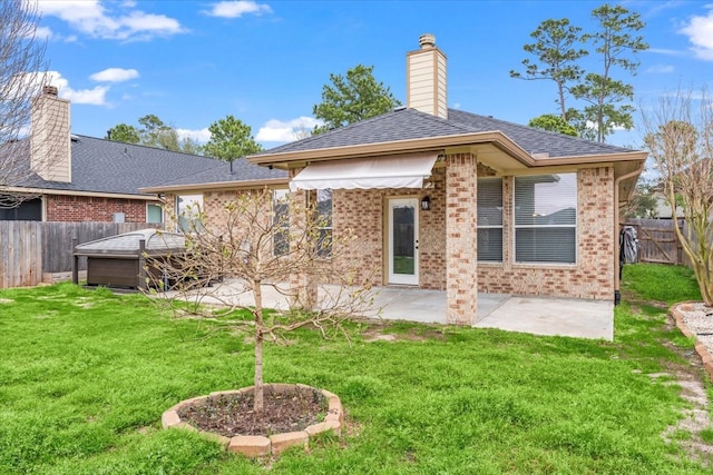 back of house with brick siding, a lawn, a patio area, and a fenced backyard