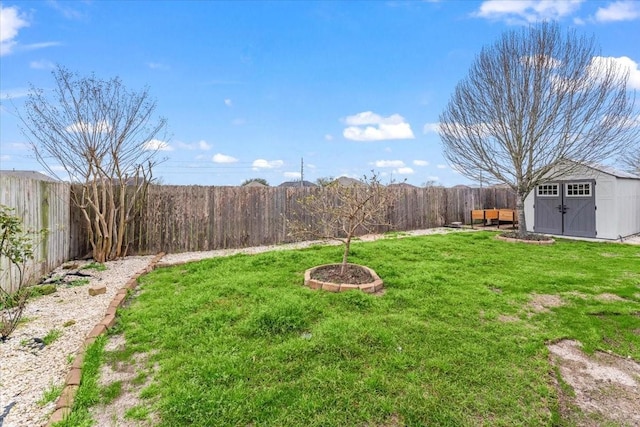 view of yard featuring an outbuilding, a fenced backyard, and a storage shed