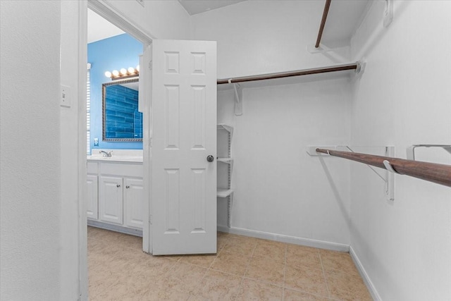 spacious closet with a sink and light tile patterned floors