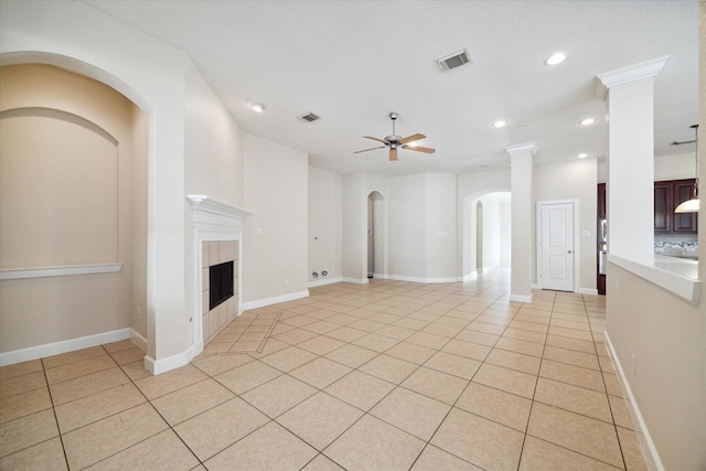 unfurnished living room with a ceiling fan, visible vents, a fireplace, and light tile patterned floors