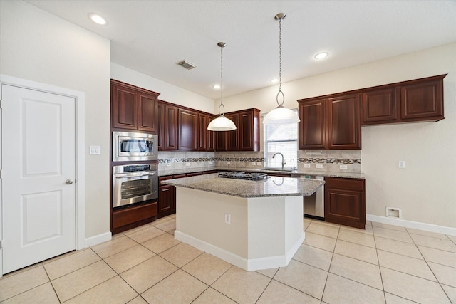 kitchen featuring light tile patterned floors, tasteful backsplash, visible vents, stainless steel appliances, and a sink