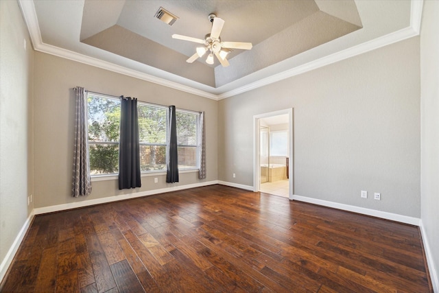 spare room with visible vents, a raised ceiling, hardwood / wood-style flooring, and baseboards