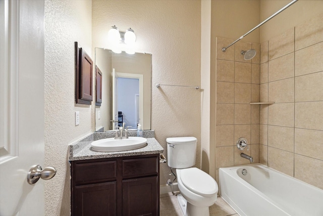 bathroom with a textured wall, shower / washtub combination, vanity, and toilet