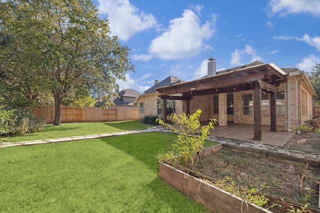 view of yard with a patio area, fence, and a garden