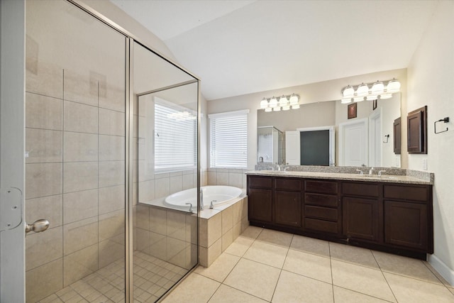 bathroom featuring a garden tub, a stall shower, vaulted ceiling, a sink, and tile patterned flooring