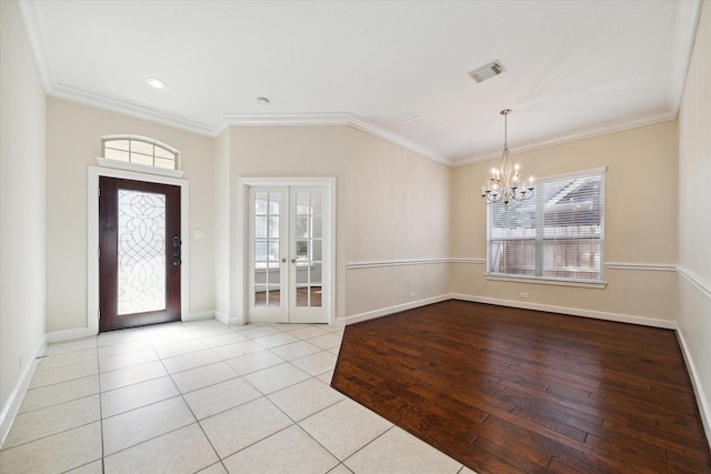 tiled foyer with visible vents, baseboards, ornamental molding, french doors, and an inviting chandelier