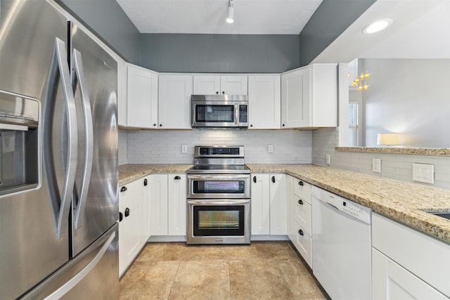 kitchen with stainless steel appliances, light stone counters, white cabinetry, and decorative backsplash