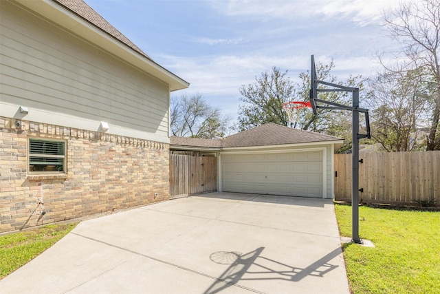 exterior space featuring a garage, concrete driveway, and fence