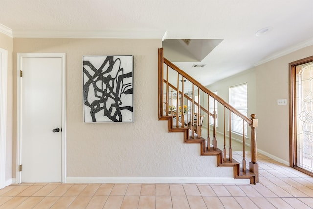 staircase with tile patterned flooring, visible vents, ornamental molding, and baseboards