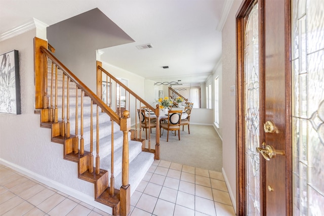 entryway featuring light tile patterned floors, baseboards, visible vents, stairway, and crown molding