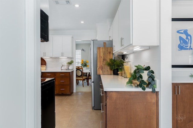 kitchen with light tile patterned floors, tasteful backsplash, ornamental molding, light countertops, and white cabinetry