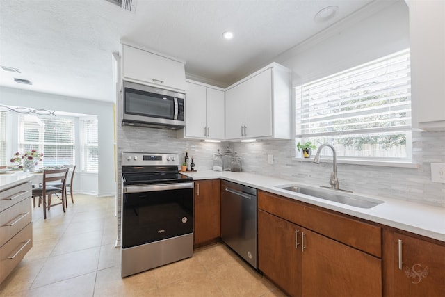 kitchen featuring decorative backsplash, appliances with stainless steel finishes, light countertops, and a sink