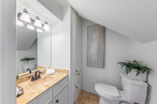 bathroom featuring baseboards, vanity, toilet, and tile patterned floors