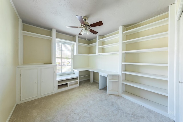 unfurnished office featuring a ceiling fan, carpet, and a textured ceiling