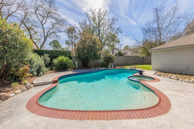 view of swimming pool featuring a pool with connected hot tub and a fenced backyard