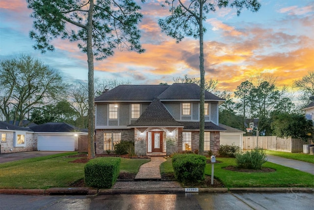 view of front of home featuring a garage, a shingled roof, fence, stucco siding, and a front lawn