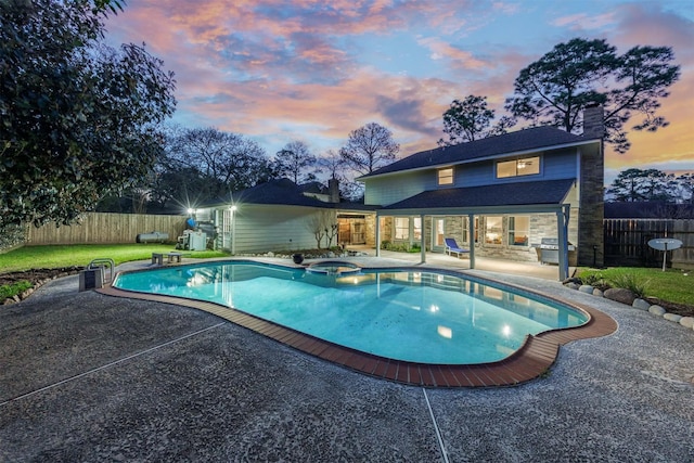 view of pool with a patio, a lawn, a fenced backyard, and a pool with connected hot tub