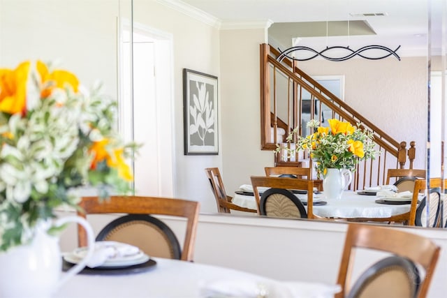 dining room featuring ornamental molding, stairway, and visible vents