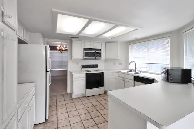 kitchen with white appliances, a peninsula, a sink, light countertops, and a notable chandelier