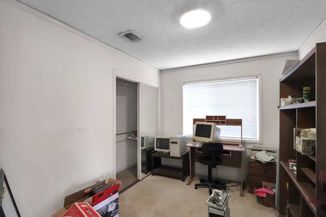 office space with visible vents, light carpet, and a textured ceiling