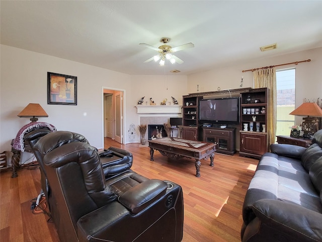 8002 Weeping Willow Pl, Missouri City, TX 77459 - living area with visible vents, wood finished floors, a ceiling fan, and a tile fireplace