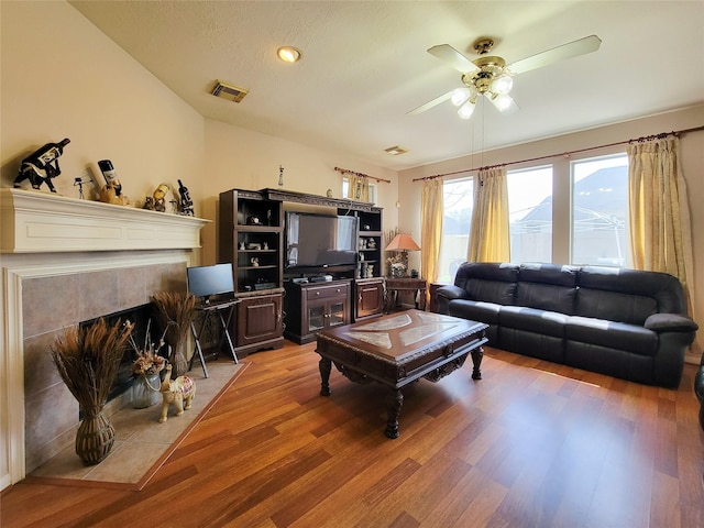 8002 Weeping Willow Pl, Missouri City, TX 77459 - living area with light wood finished floors, visible vents, a tile fireplace, and ceiling fan