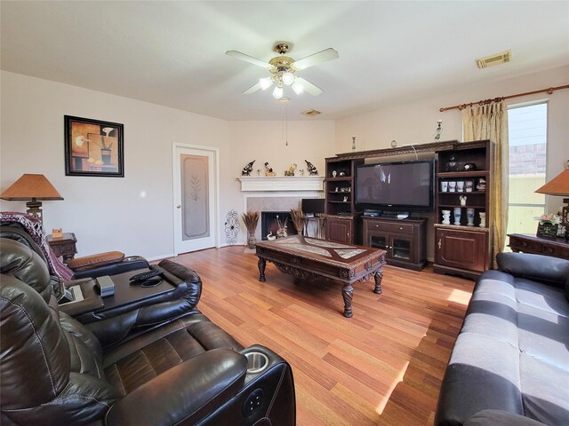 8002 Weeping Willow Pl, Missouri City, TX 77459 - living room featuring a tile fireplace, wood finished floors, visible vents, and ceiling fan