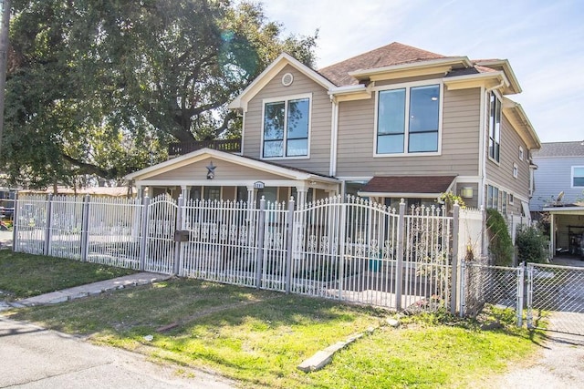 view of front of property with roof with shingles, a fenced front yard, and a gate