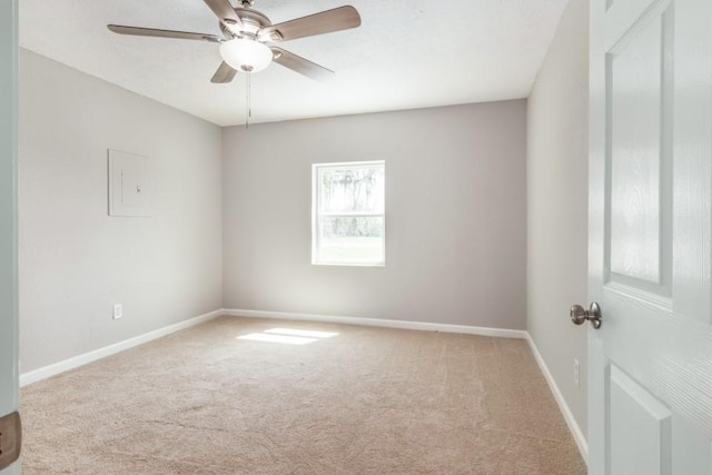 carpeted spare room featuring baseboards and ceiling fan