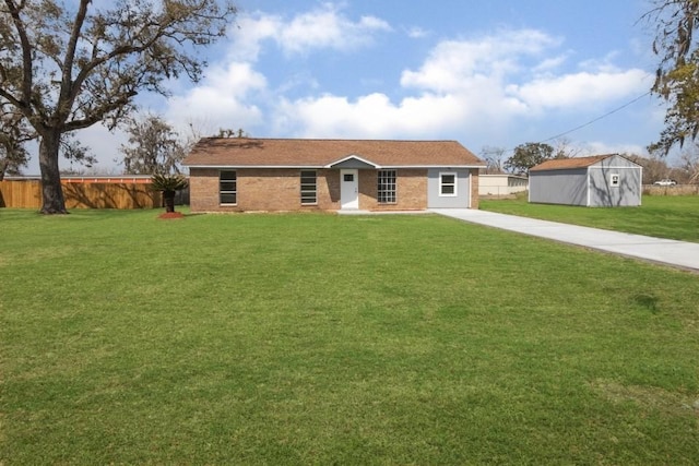 ranch-style home featuring concrete driveway, a front yard, and fence