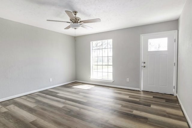 foyer entrance with a textured ceiling, wood finished floors, baseboards, and ceiling fan