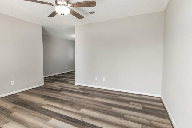 unfurnished room with ceiling fan, wood finished floors, visible vents, and baseboards