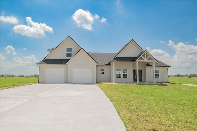 modern farmhouse style home featuring a garage, driveway, roof with shingles, board and batten siding, and a front yard