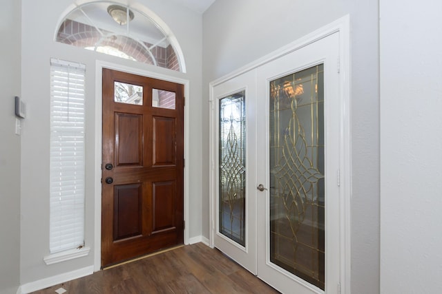 entryway with dark wood-style floors, baseboards, and french doors