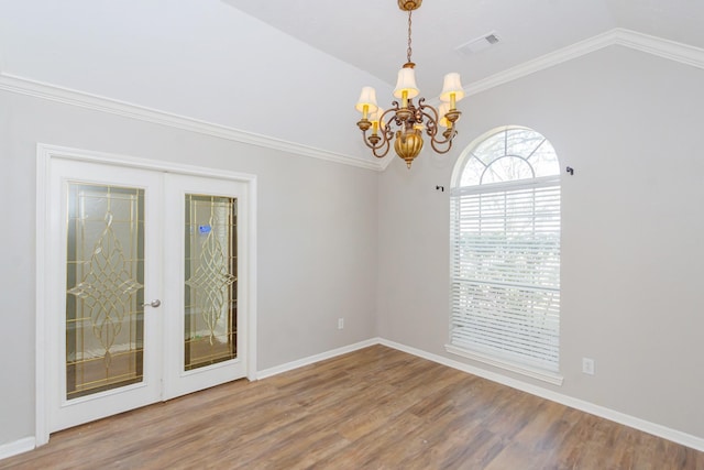 empty room with lofted ceiling, a notable chandelier, wood finished floors, visible vents, and french doors