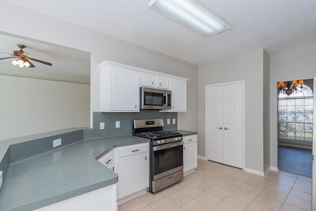 kitchen with light tile patterned floors, baseboards, white cabinets, appliances with stainless steel finishes, and ceiling fan with notable chandelier