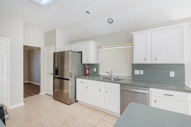 kitchen with light tile patterned floors, a sink, baseboards, white cabinets, and appliances with stainless steel finishes