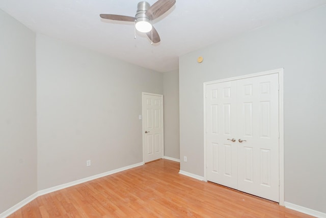 unfurnished bedroom with a closet, baseboards, ceiling fan, and light wood finished floors