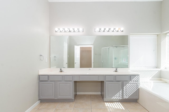 bathroom with double vanity, tile patterned floors, a sink, a shower stall, and a bath