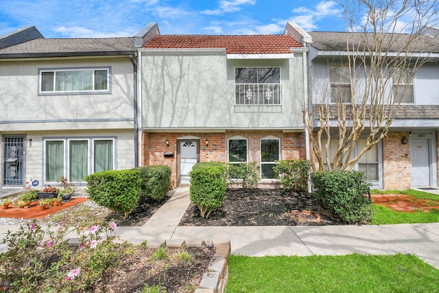 townhome / multi-family property featuring stucco siding and brick siding