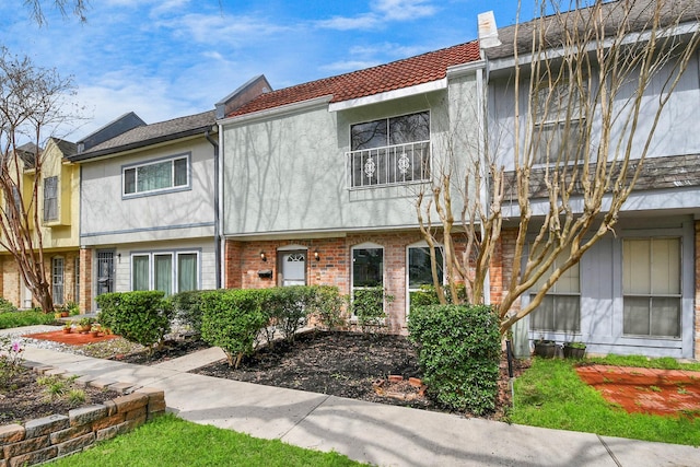 townhome / multi-family property featuring brick siding and stucco siding