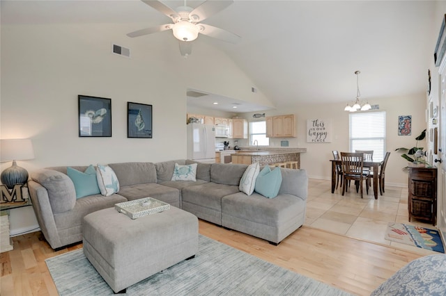 living room featuring visible vents, plenty of natural light, and light wood-style flooring