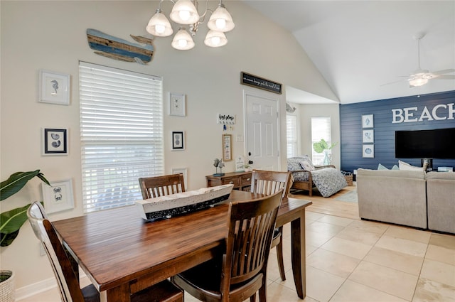 dining space featuring vaulted ceiling, ceiling fan with notable chandelier, and light tile patterned flooring