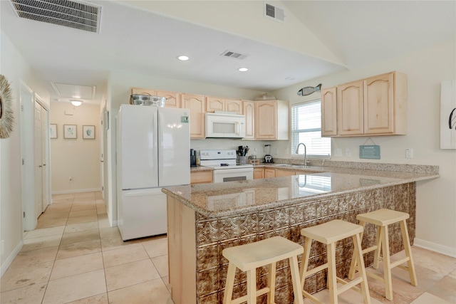 kitchen featuring a sink, white appliances, light brown cabinets, and visible vents