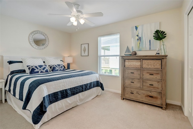 bedroom with baseboards, ceiling fan, and light colored carpet