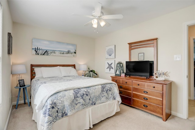 bedroom with light colored carpet, ceiling fan, and baseboards