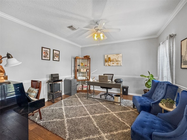 office space featuring visible vents, crown molding, ceiling fan, and wood finished floors