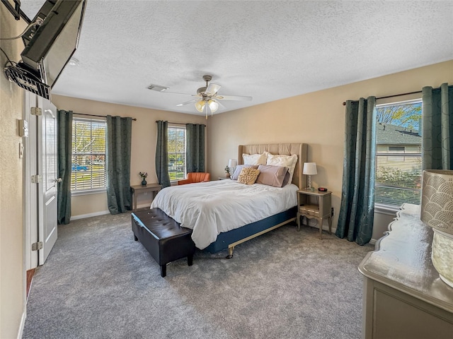 carpeted bedroom featuring a textured ceiling, baseboards, visible vents, and ceiling fan