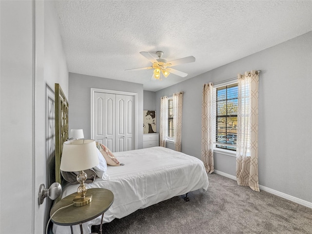 bedroom with a ceiling fan, baseboards, carpet floors, a closet, and a textured ceiling