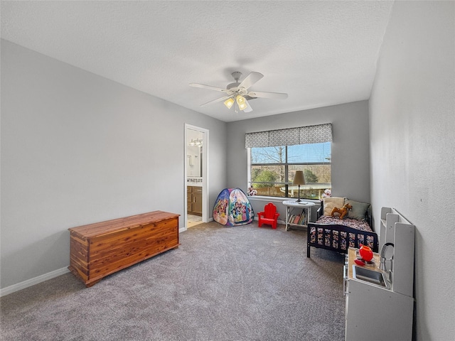 recreation room featuring baseboards, ceiling fan, a textured ceiling, and carpet